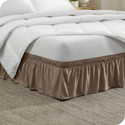 The corner of a bed with a polyester bed skirt on it