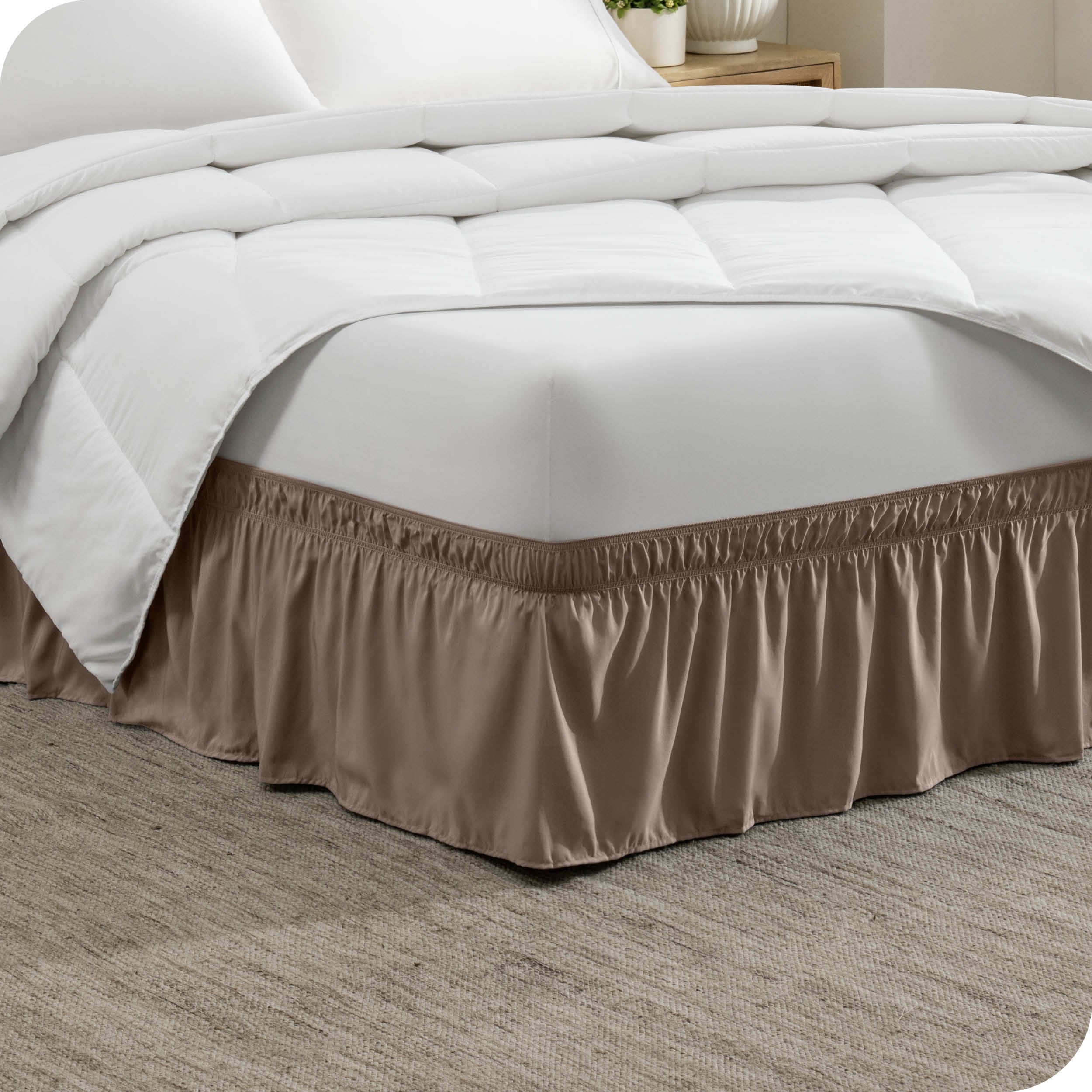 The corner of a bed with a polyester bed skirt on it