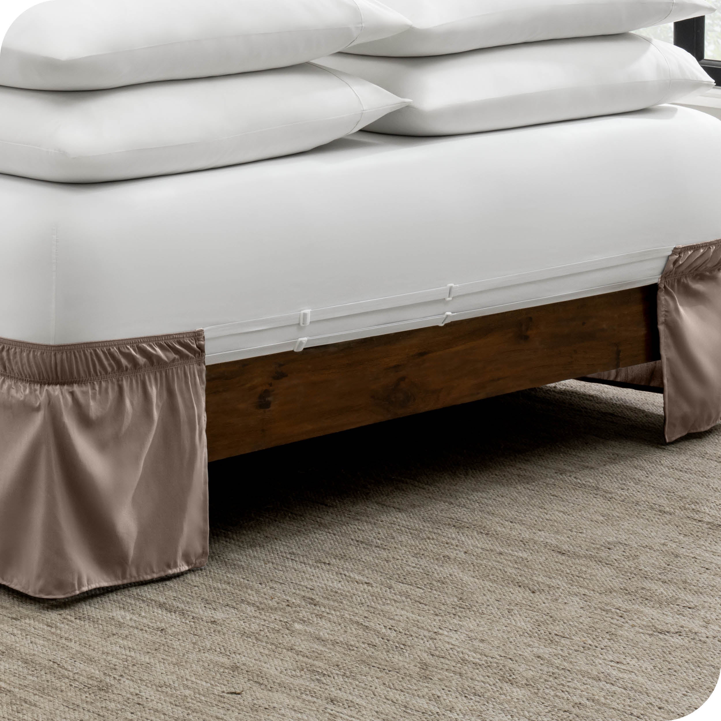 The adjustable elastic belt of a bed skirt wrapped around the mattress