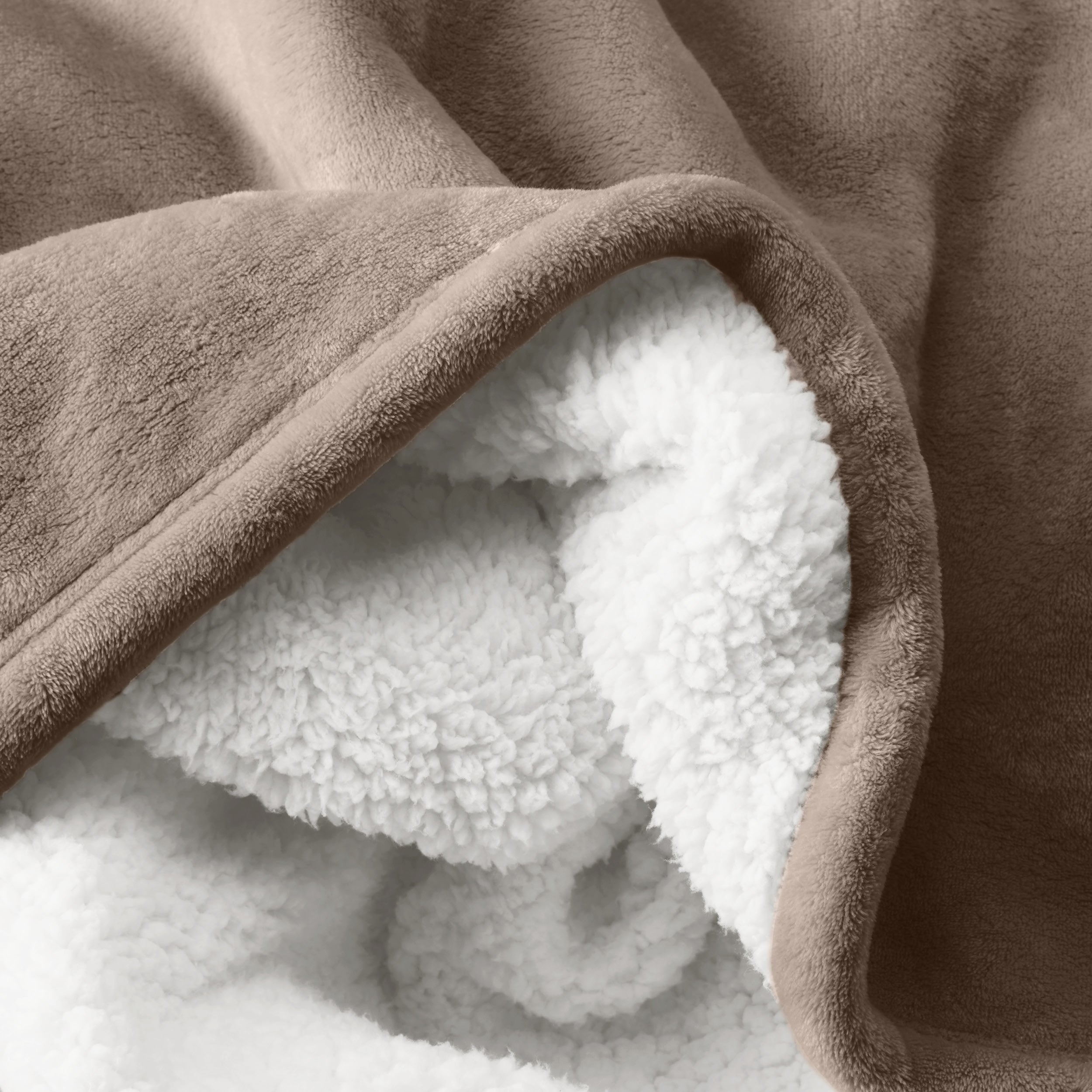 Close up of sherpa blanket showing texture of velvety soft side and sherpa backing