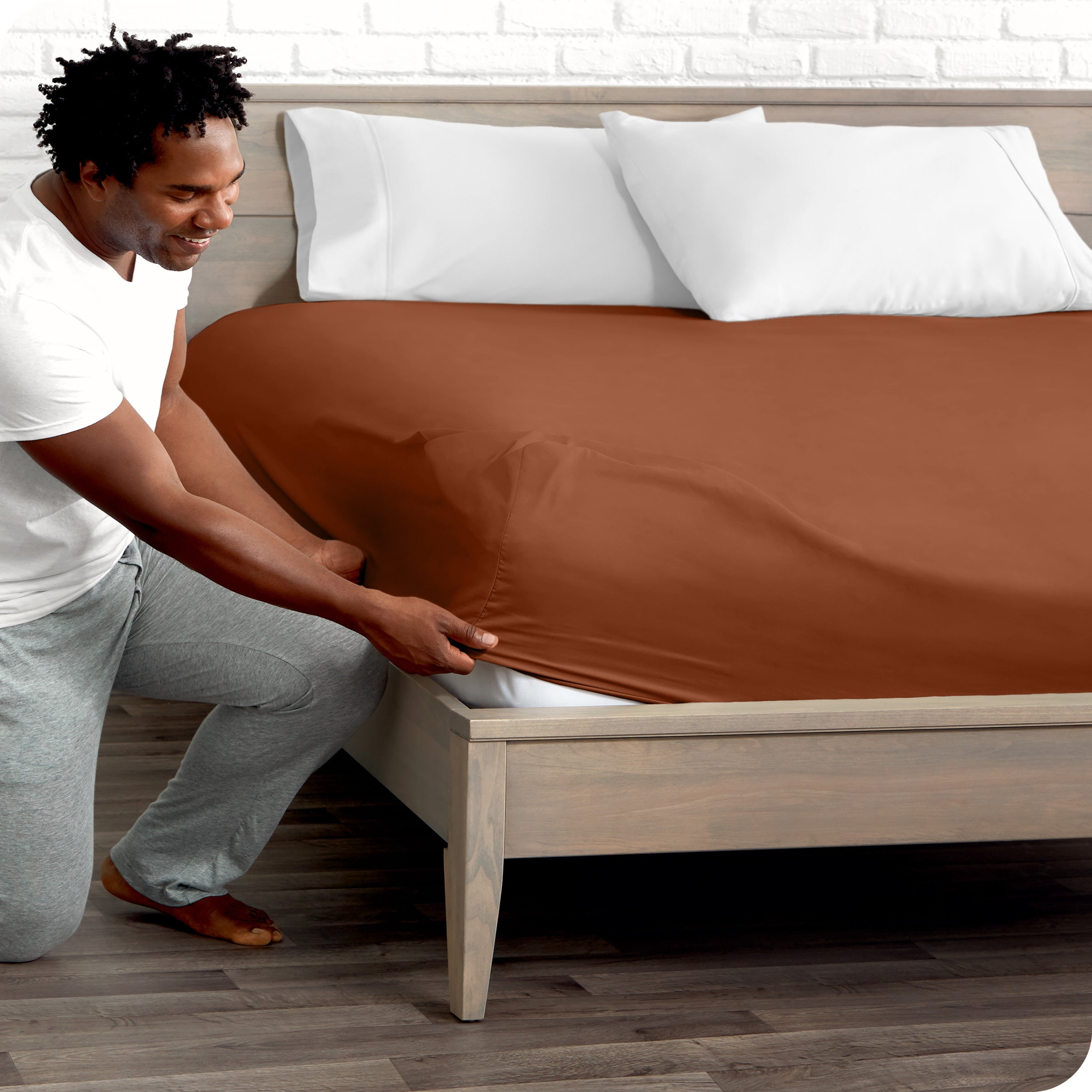 A man putting the microfiber fitted sheet on a mattress. 