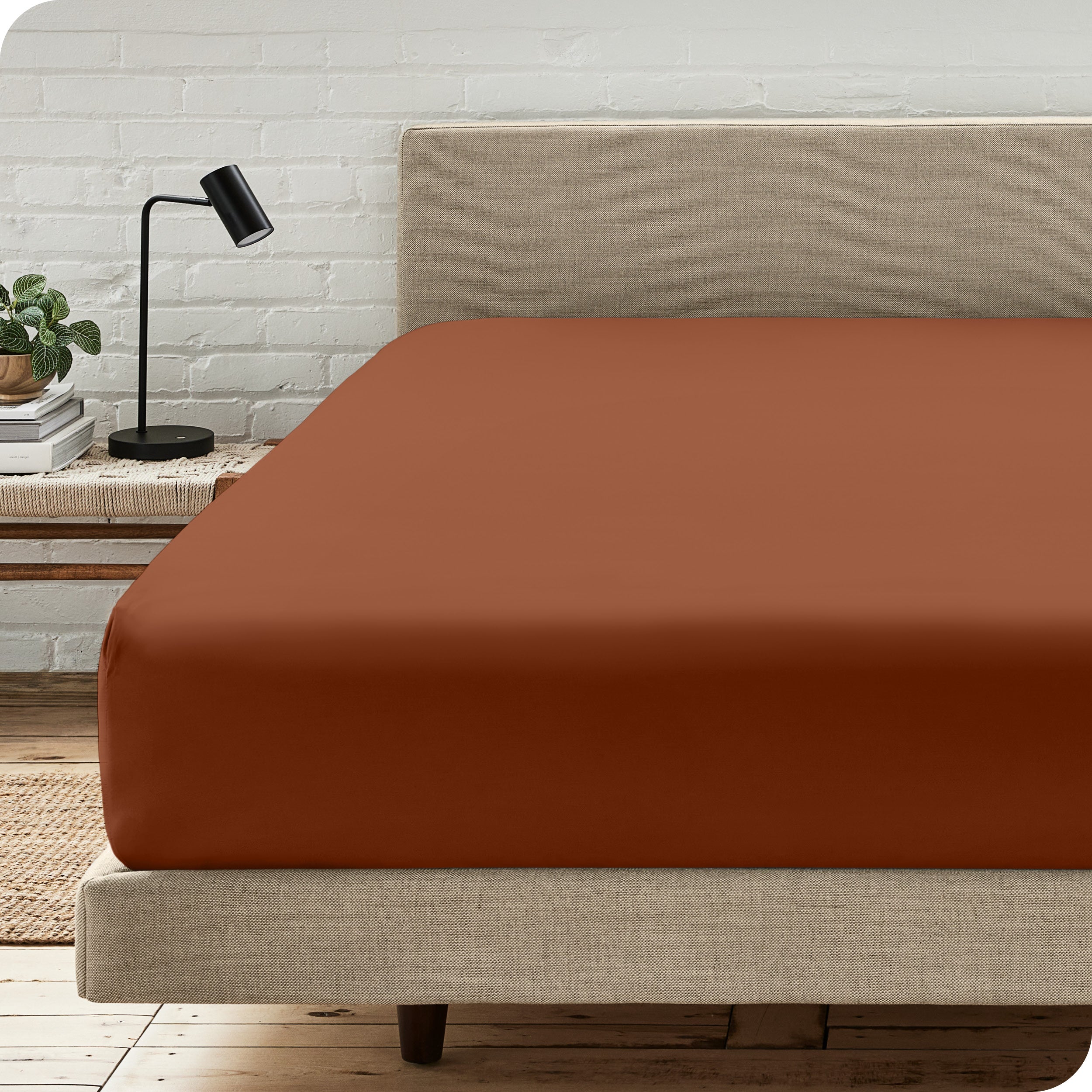 A bed with a microfiber fitted sheet on the mattress. 
