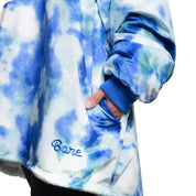 An adult with a hooded wearable blanket on
