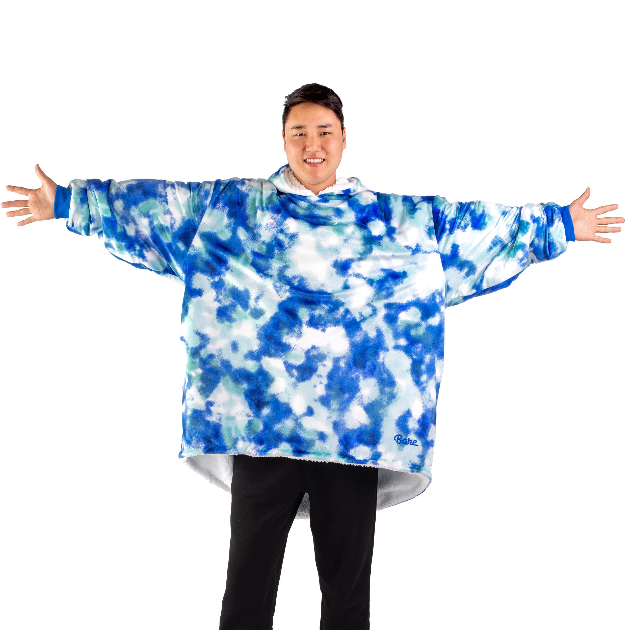 An adult with a hooded wearable blanket on