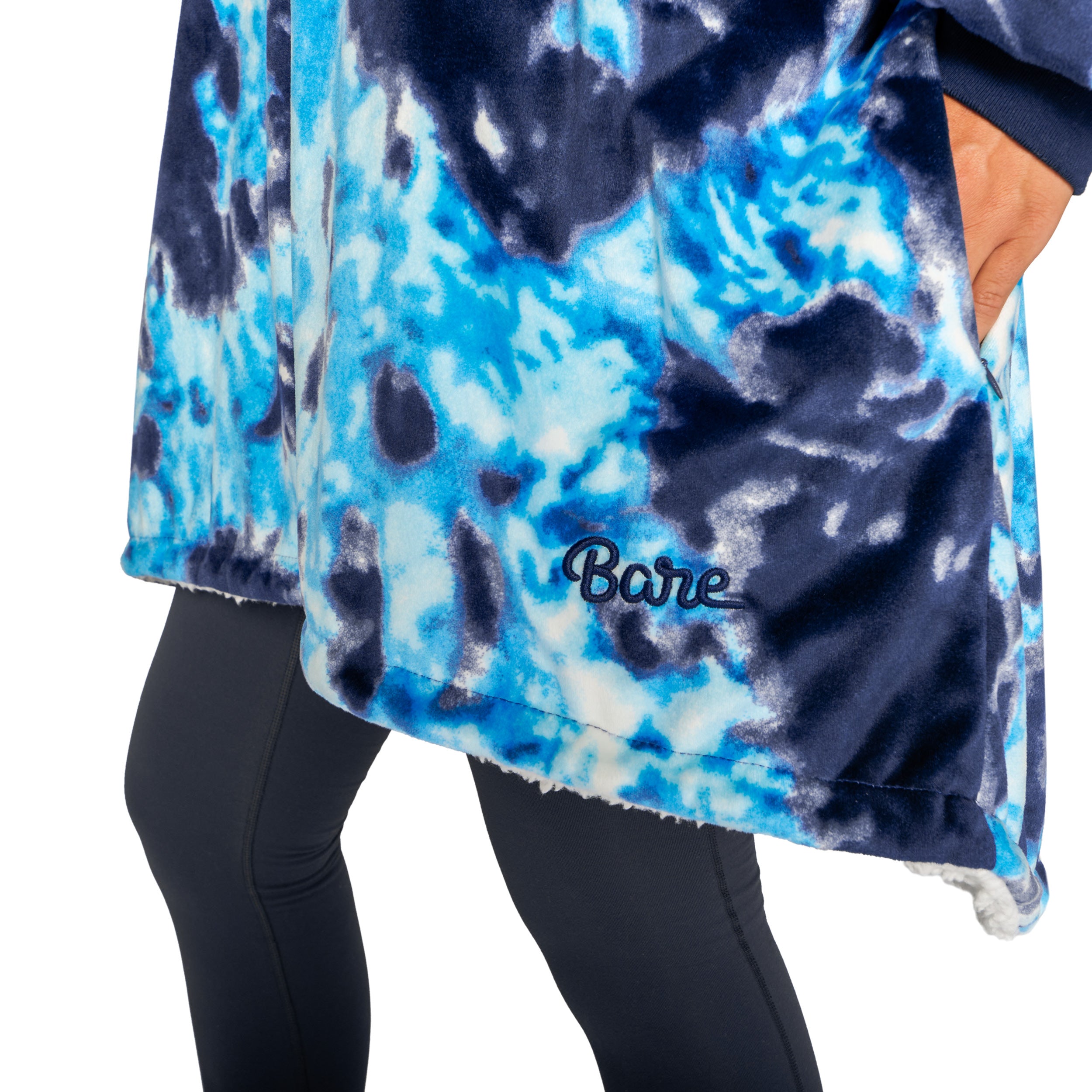 An adult with a hooded wearable blanket on