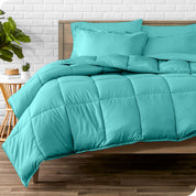 A wooden bed frame with sheets, pillow shams and a comforter on the bed