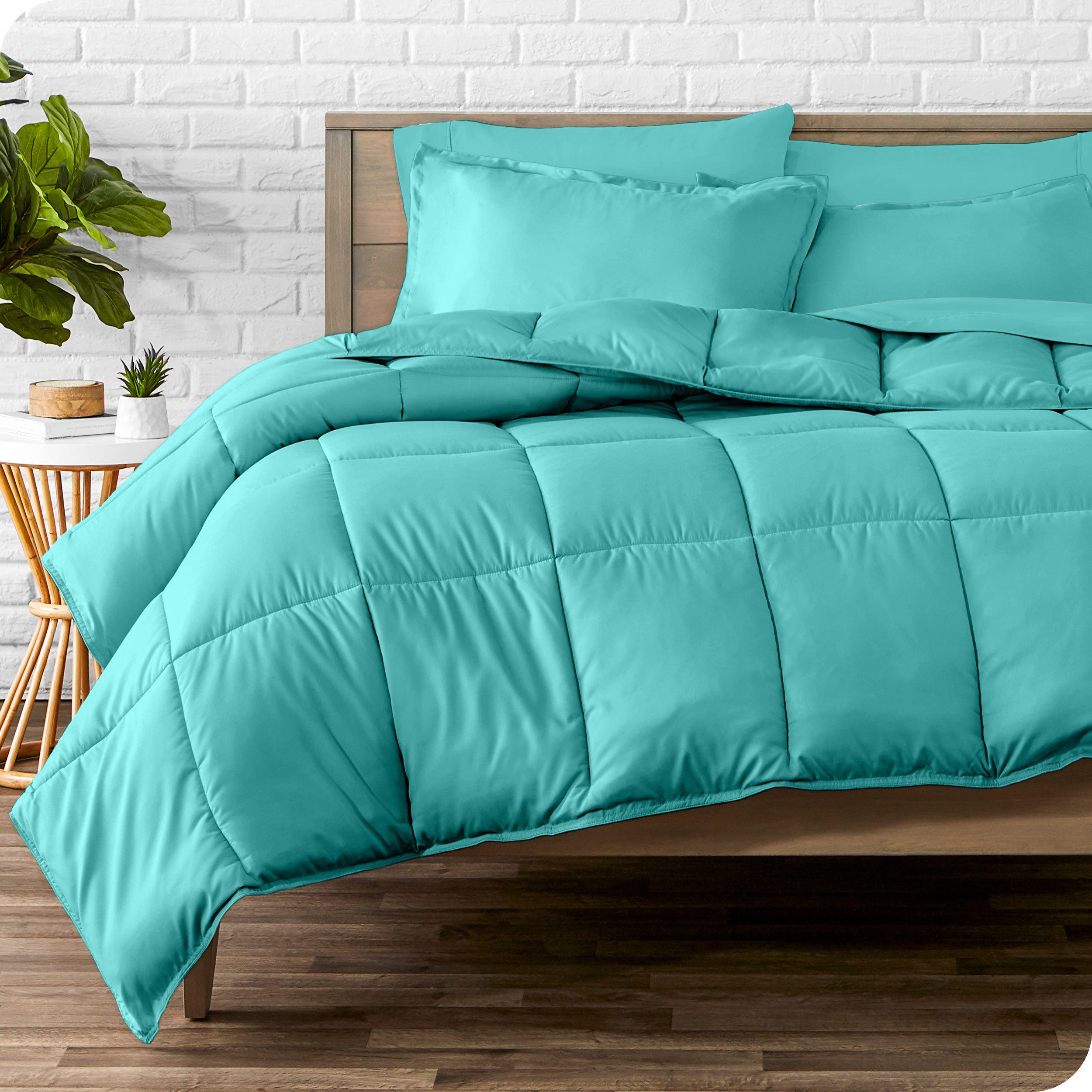 A wooden bed frame with sheets, pillow shams and a comforter on the bed