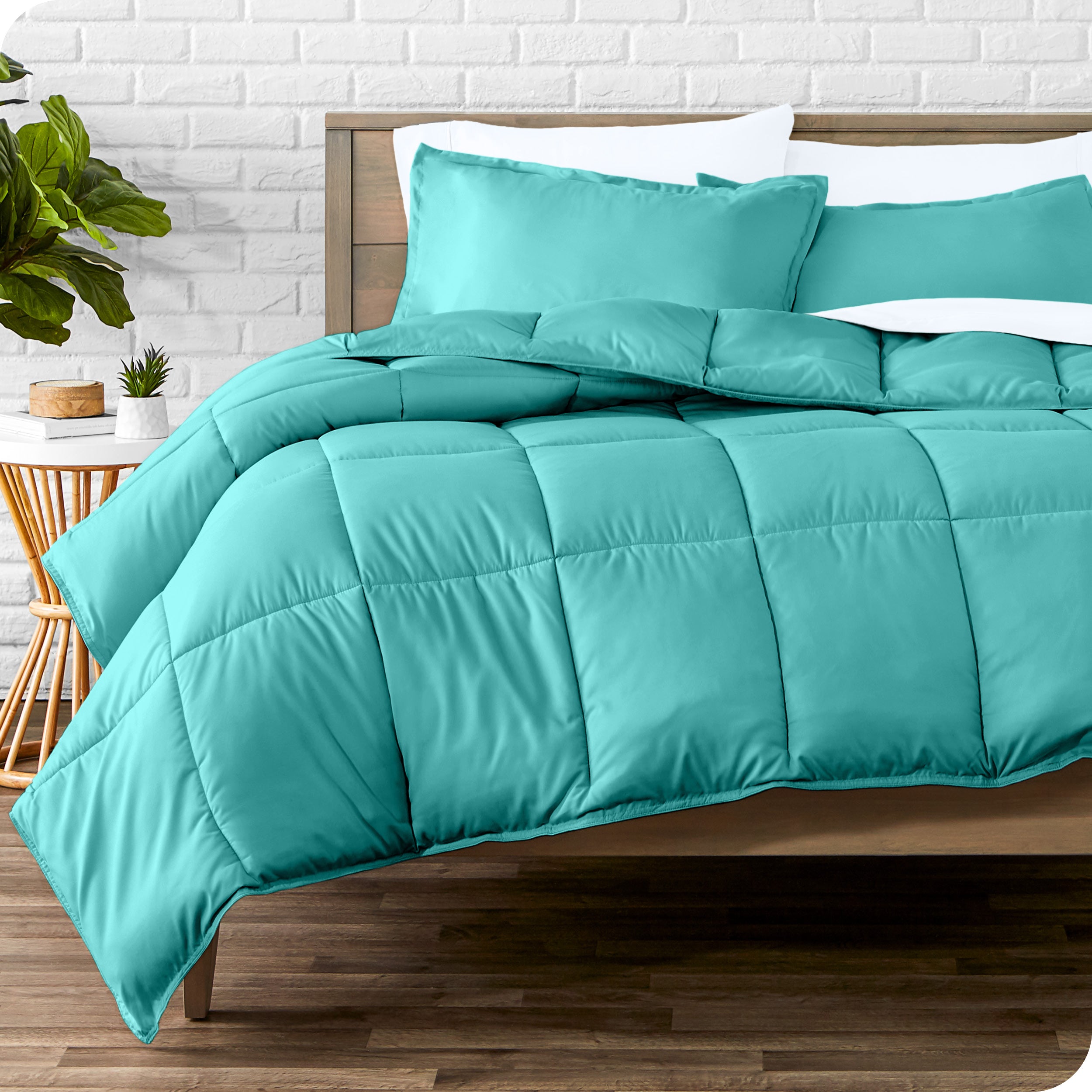 A wooden bed frame with sheets, pillow shams and a comforter on the bed