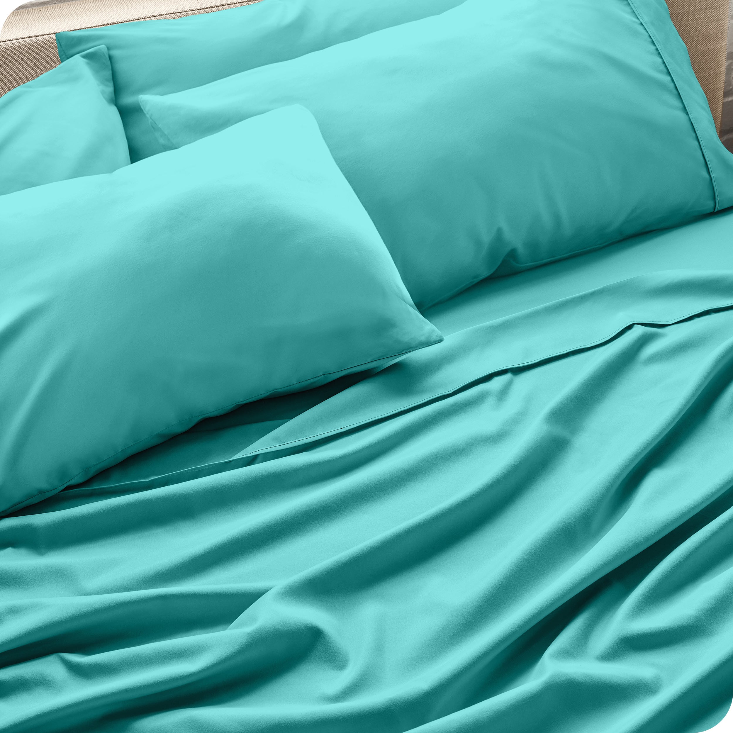 Close up of the microfiber bed sheets on a bed with four pillows.