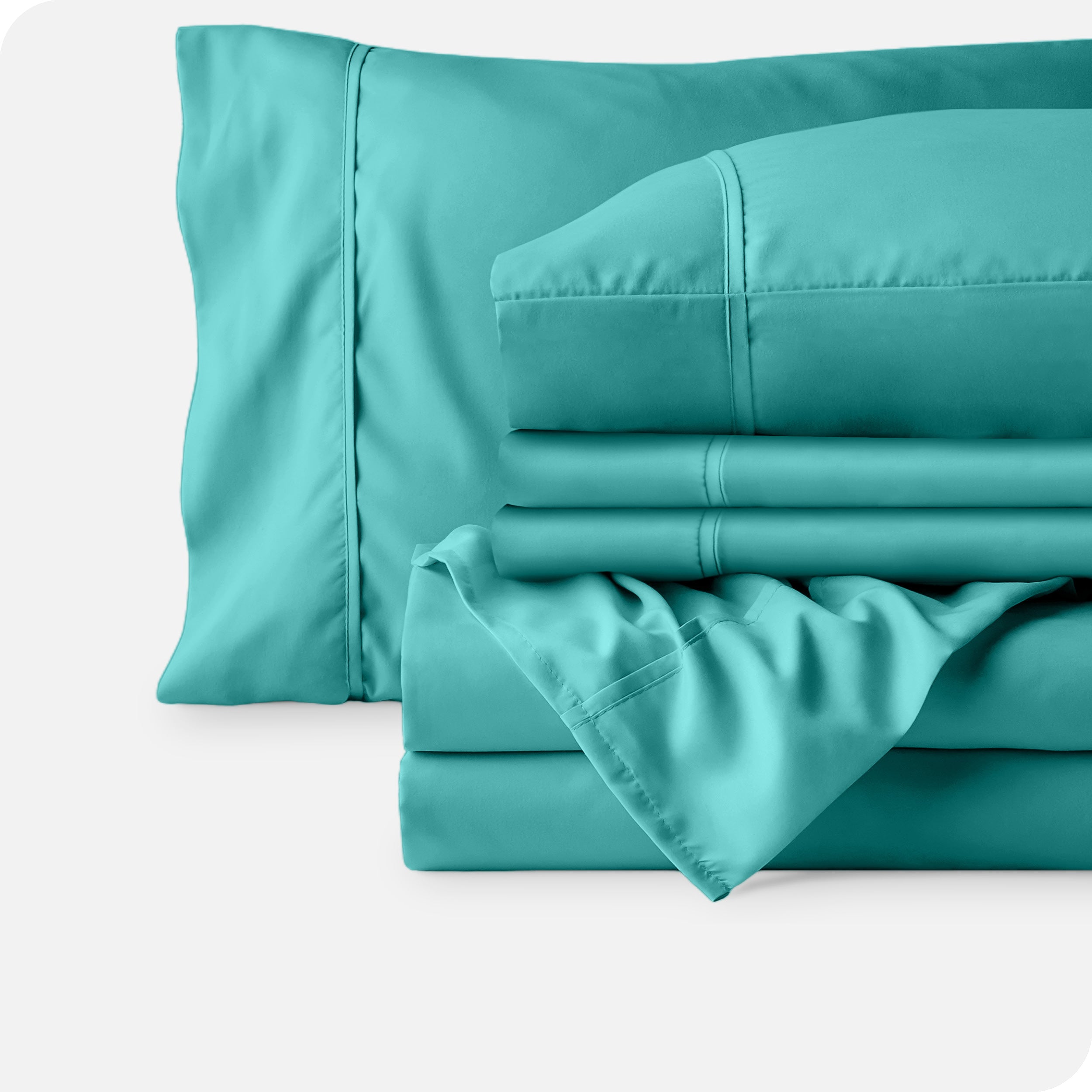Microfiber sheets neatly folded with corner draped over, two folded pillowcases and two display pillows.