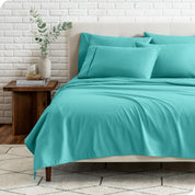 End view of a modern bed with the microfiber sheets on the bed with four pillows.