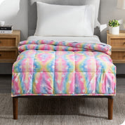 A printed weighted blanket hanging off the end of a twin size bed