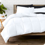 A wooden bed frame with sheets, pillow shams and a comforter on the bed