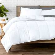 A wooden bed frame with sheets, pillow shams and a comforter on the bed