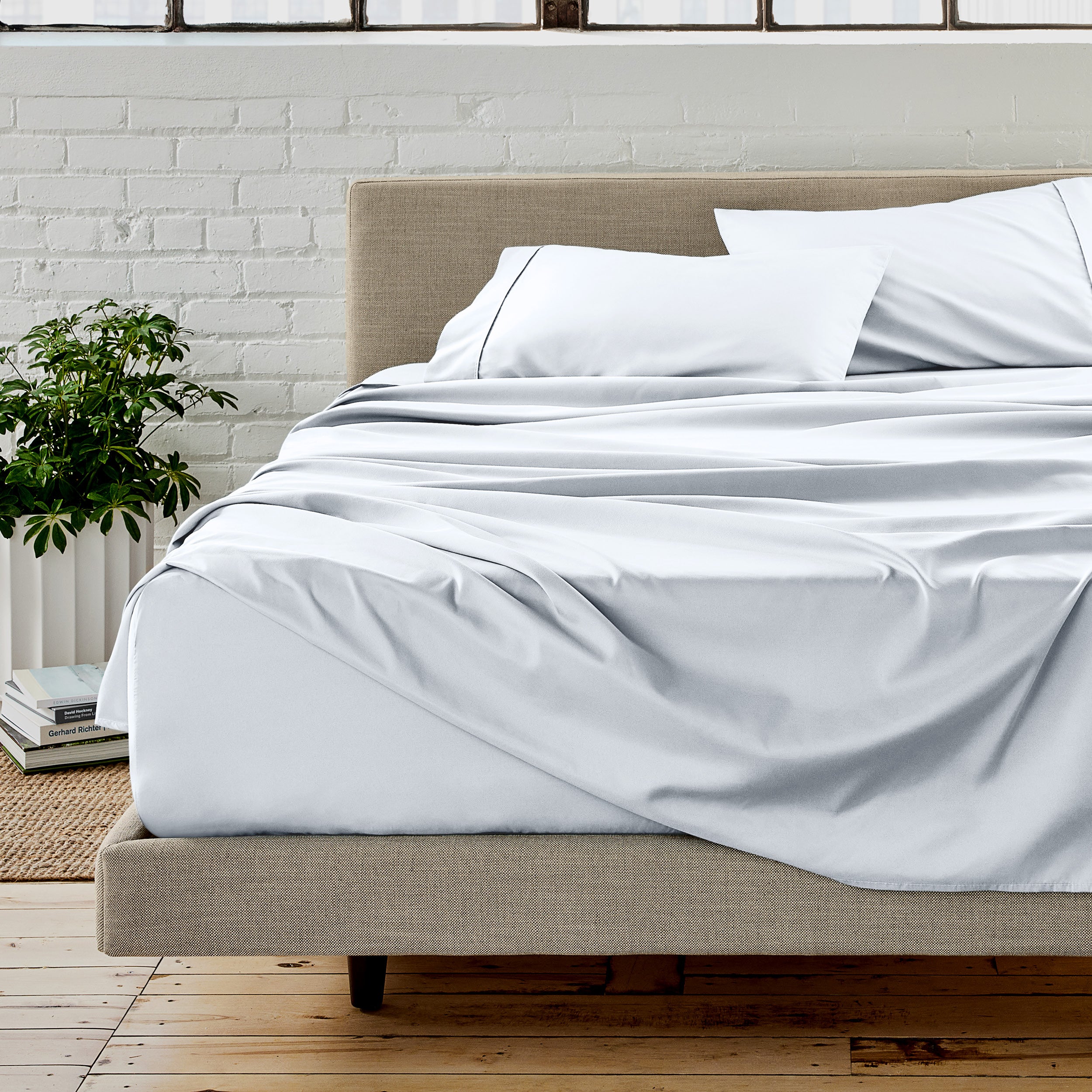 Microfiber sheet set on a bed with a white brick wall in the background