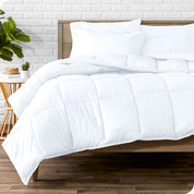 A wooden bed frame with sheets, pillow shams and a comforter on the bed