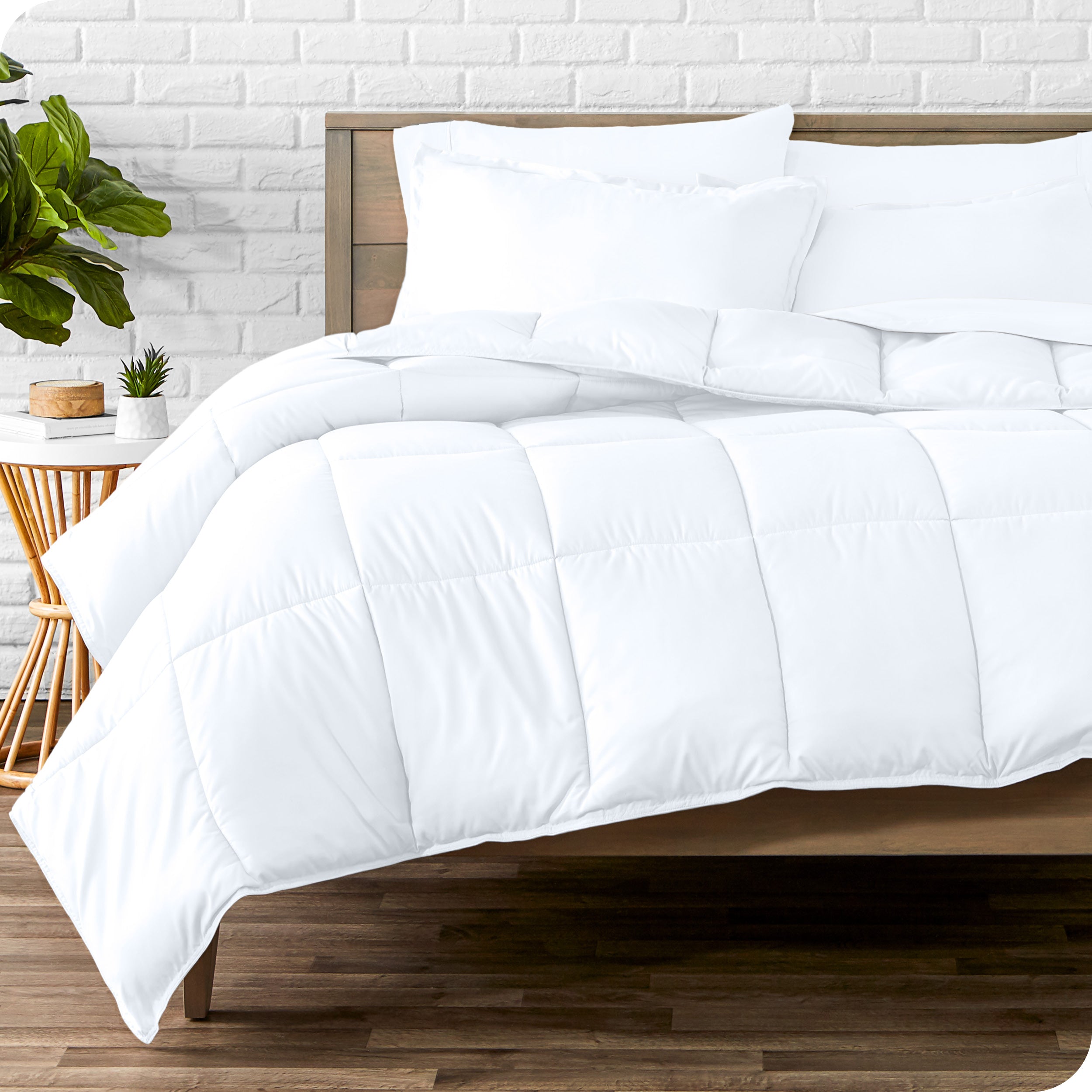 A wooden bed frame with sheets, pillow shams and a comforter on the bed
