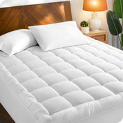 A mattress pad on a bed with a wooden headboard