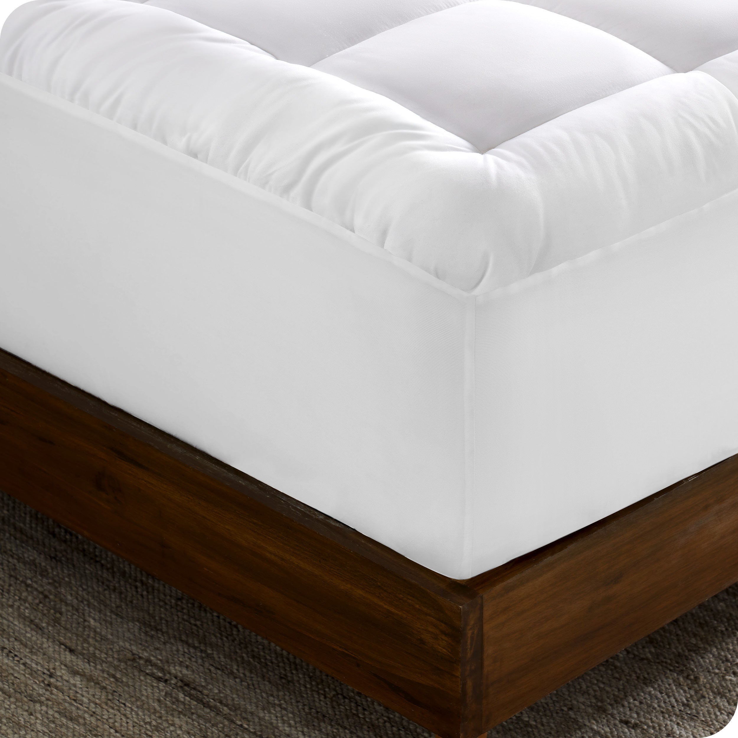 The corner of a mattress with a mattress pad on it
