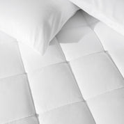 Close up of a cotton top mattress pad with pillows from above.
