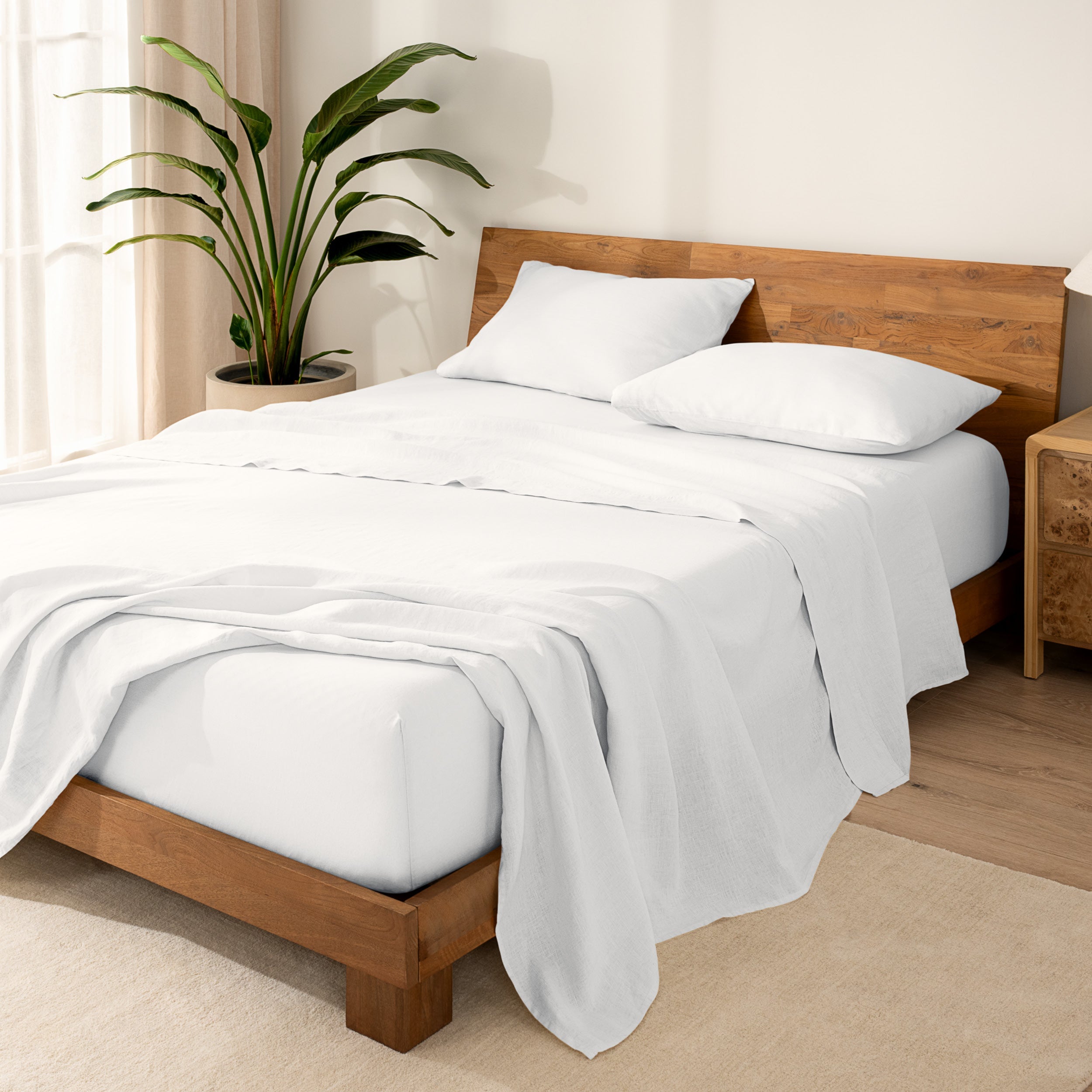Wooden bed frame with  linen sheets on the mattress