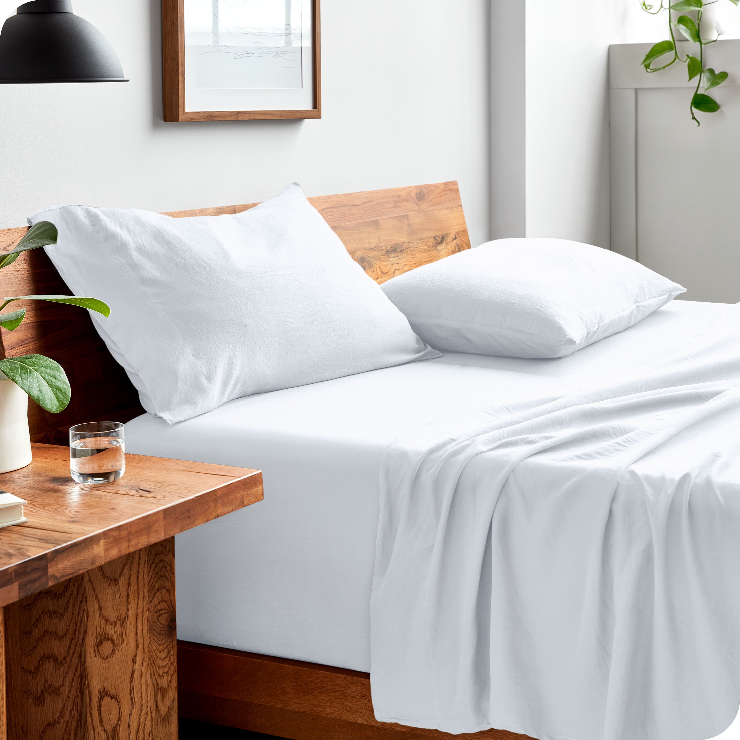 Side view of bed made with fitted sheet, pillowcases, and top sheet