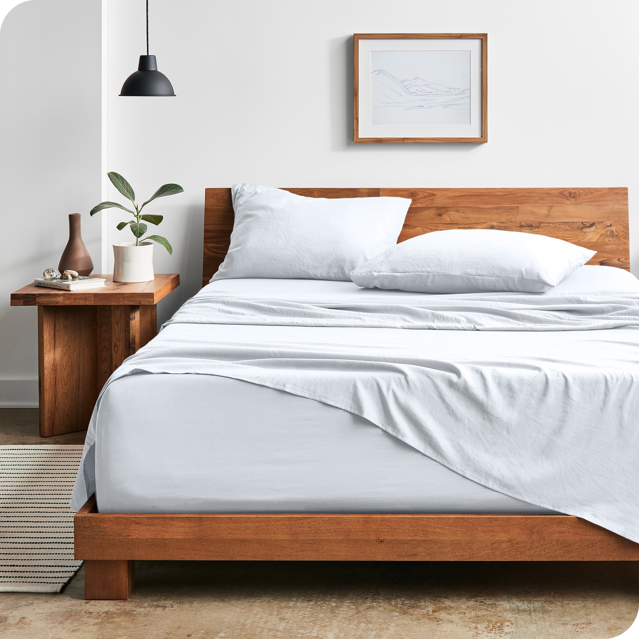 Modern bedroom with Sandwashed sheets draped over the end and side of mattress

