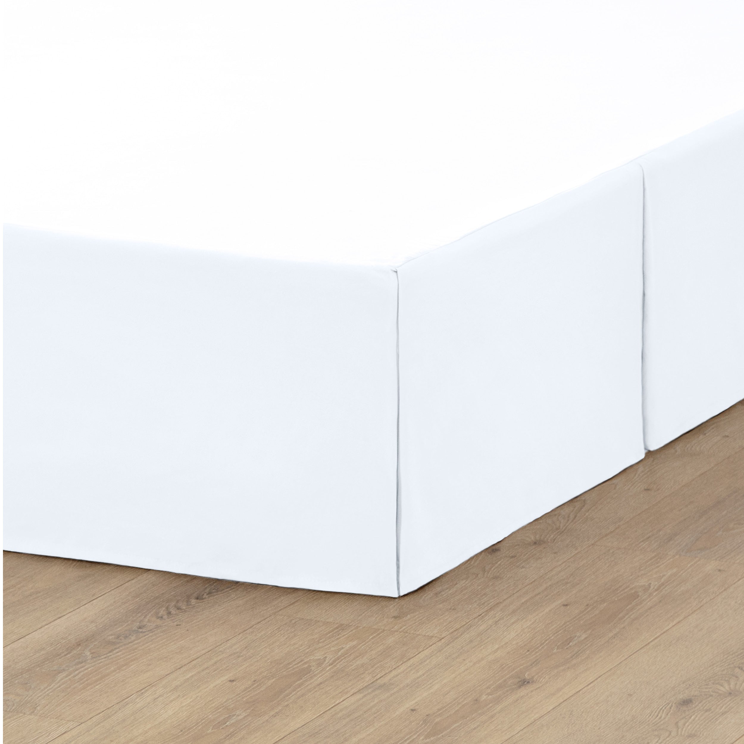 A box spring with a bed skirt on it