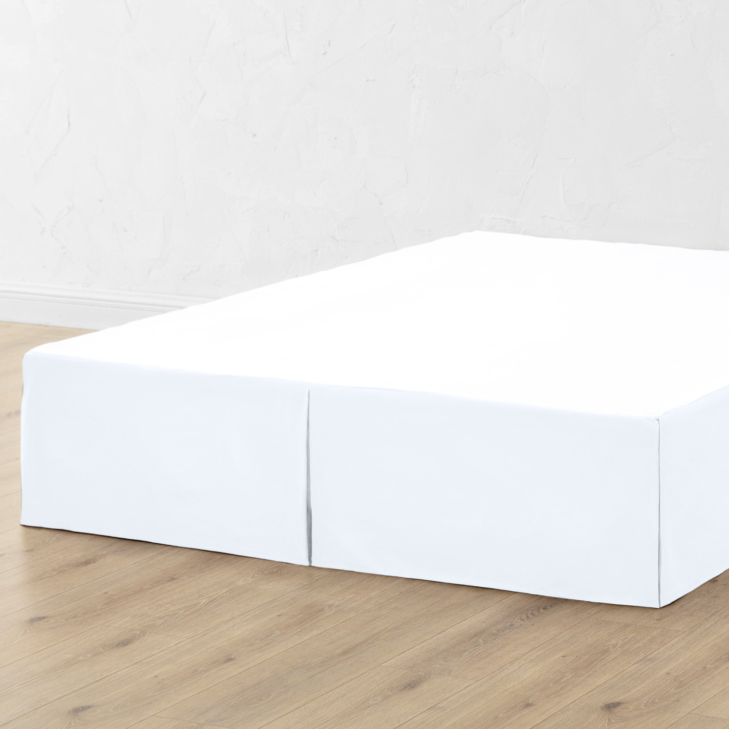 A bed skirt draped over a box spring