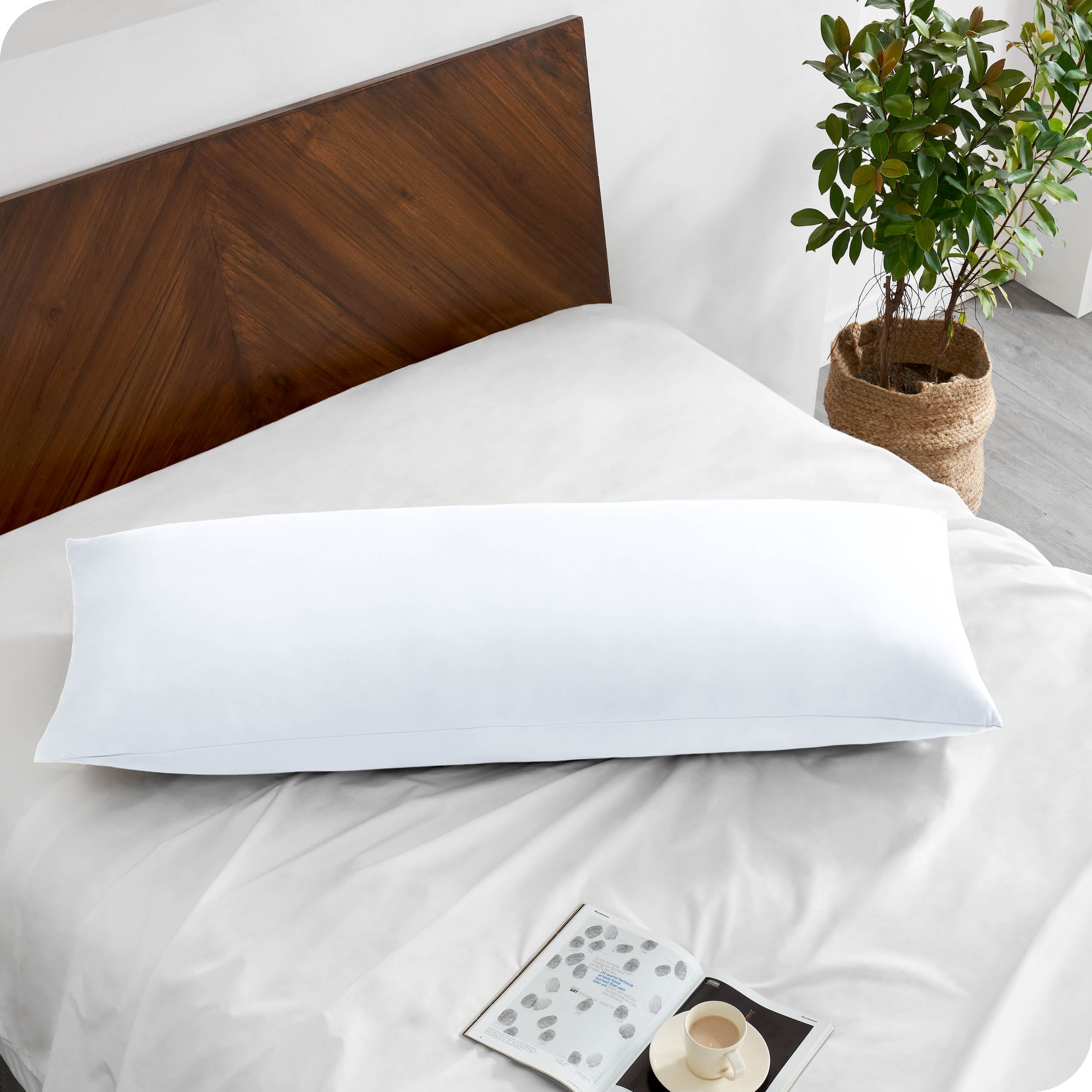 A body pillowcase on a pillow on a bed with all white bedding