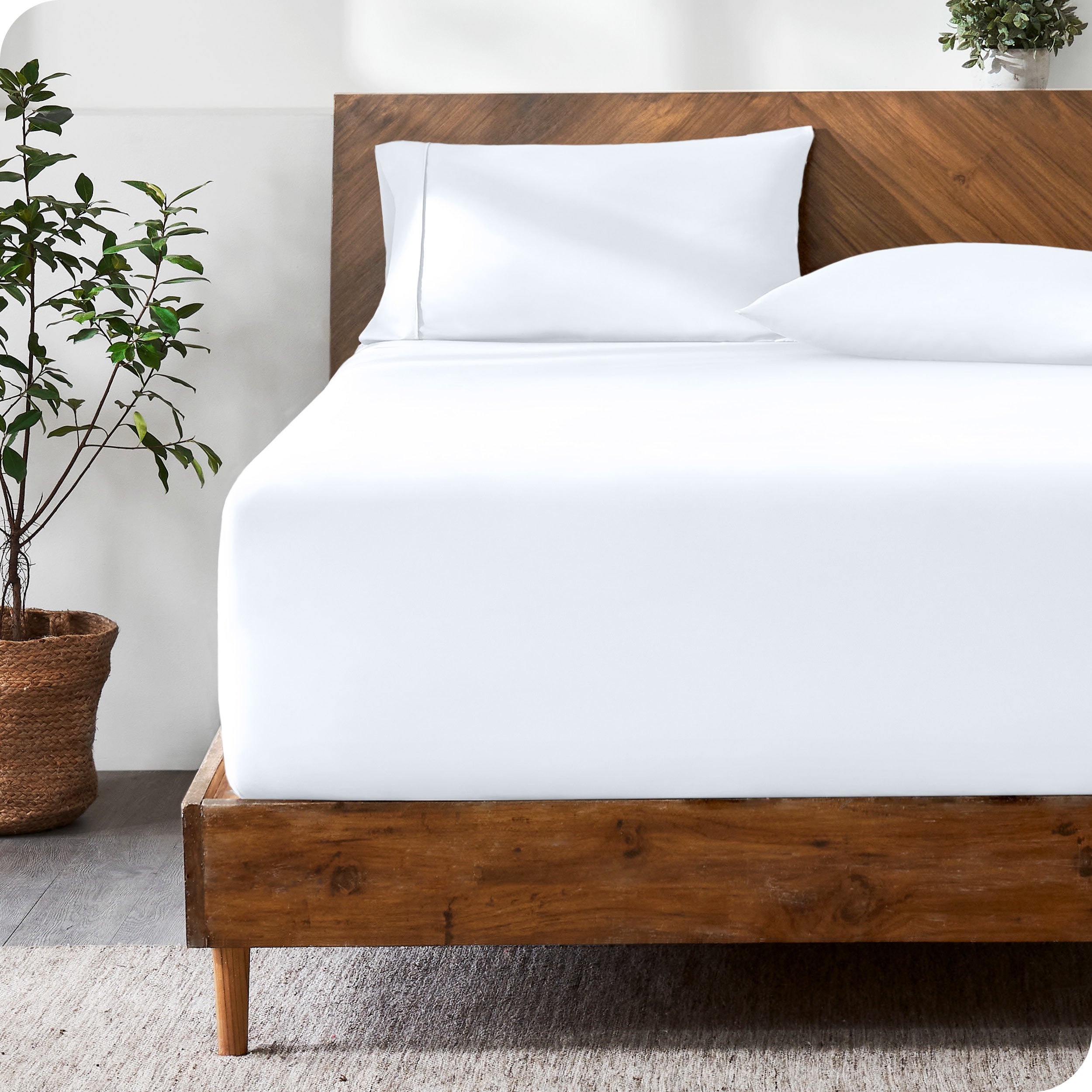 A modern bed with a fitted microfiber sheet made on the mattress. 