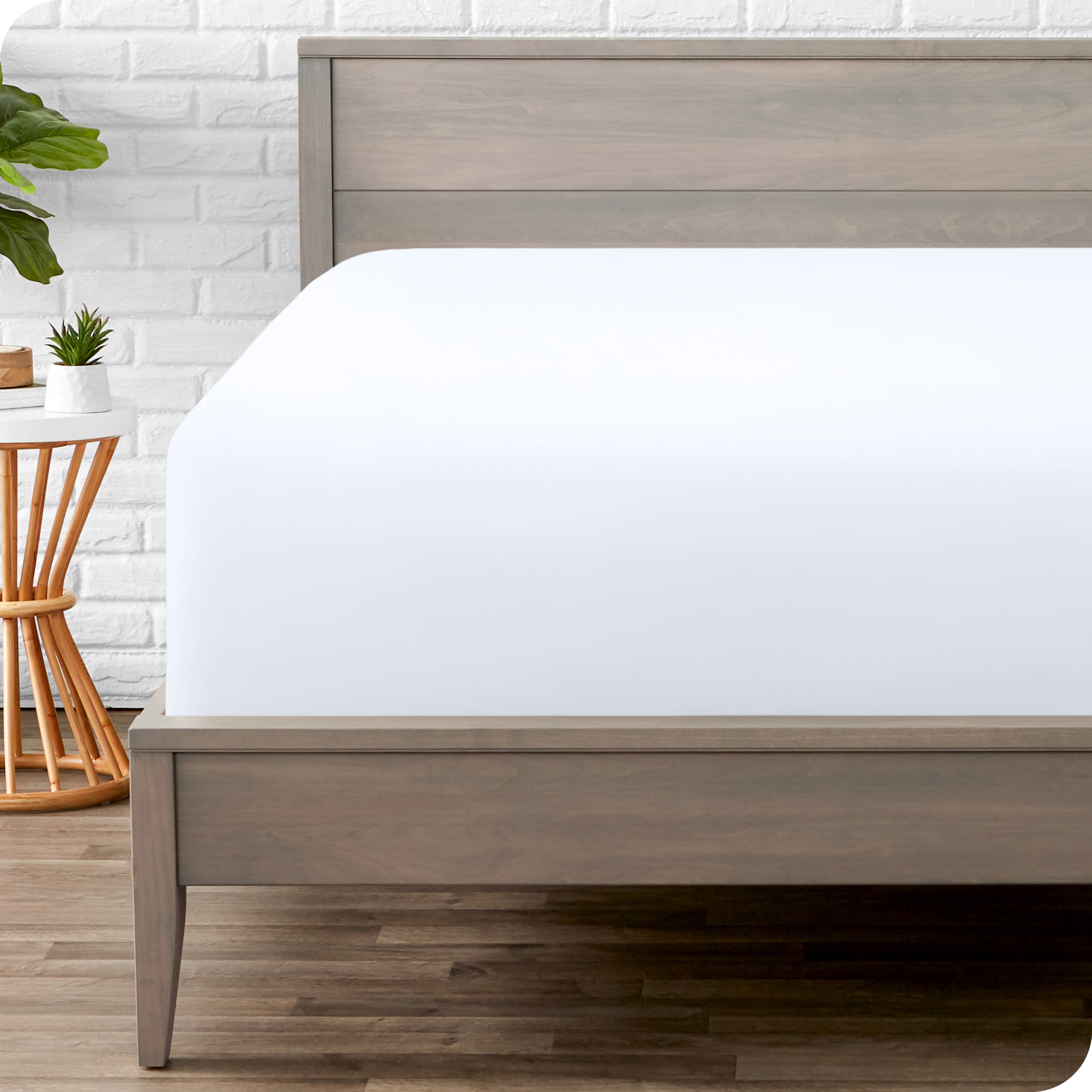 A modern bed with a fitted microfiber sheet on it