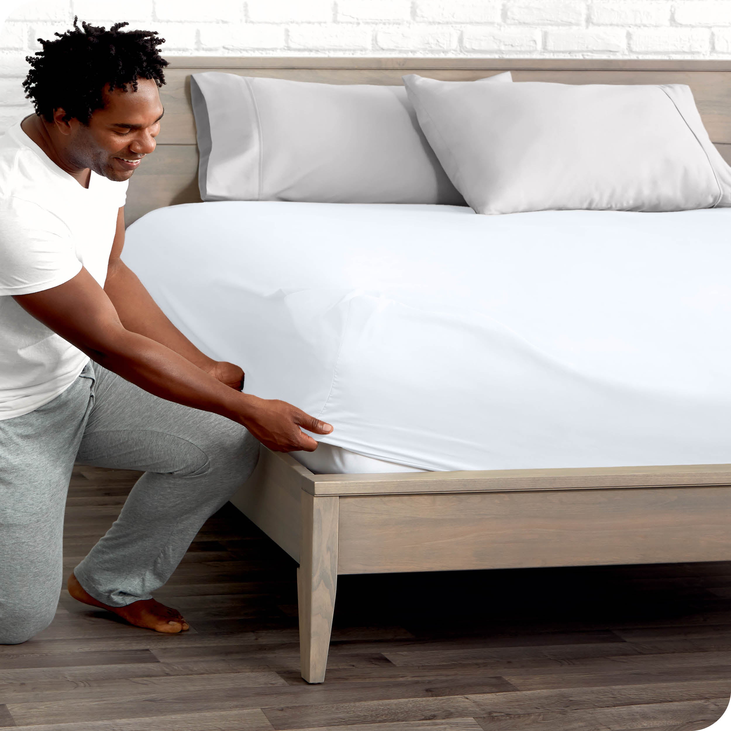 A man putting the microfiber fitted sheet on a mattress. 