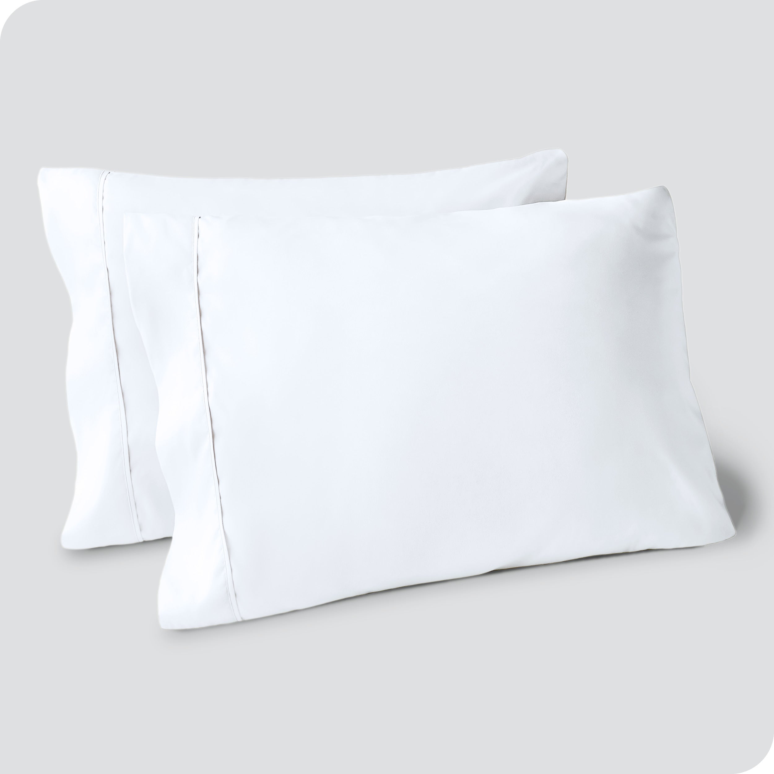 Two pillows on a white background with blue pillowcases on them