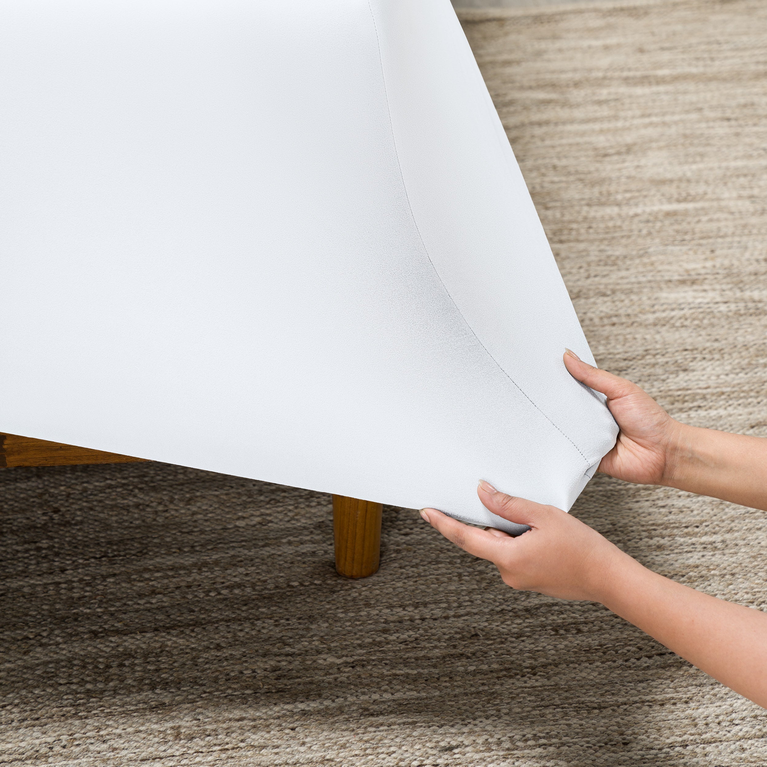 Person putting a stretch fitted sheet on a mattress