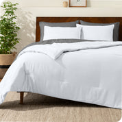 A comforter set on a bed with a dark wooden headboard