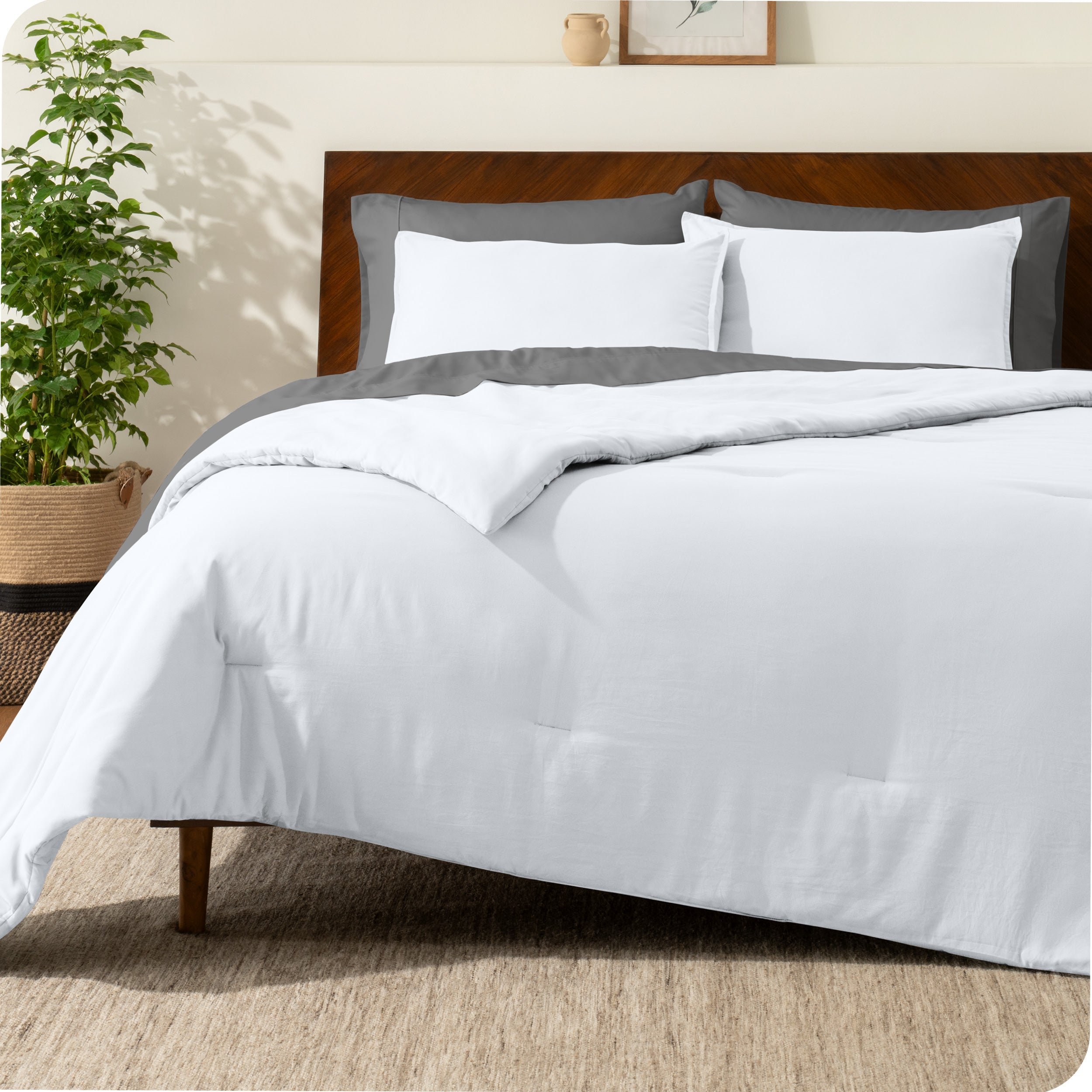 A comforter set on a bed with a dark wooden headboard