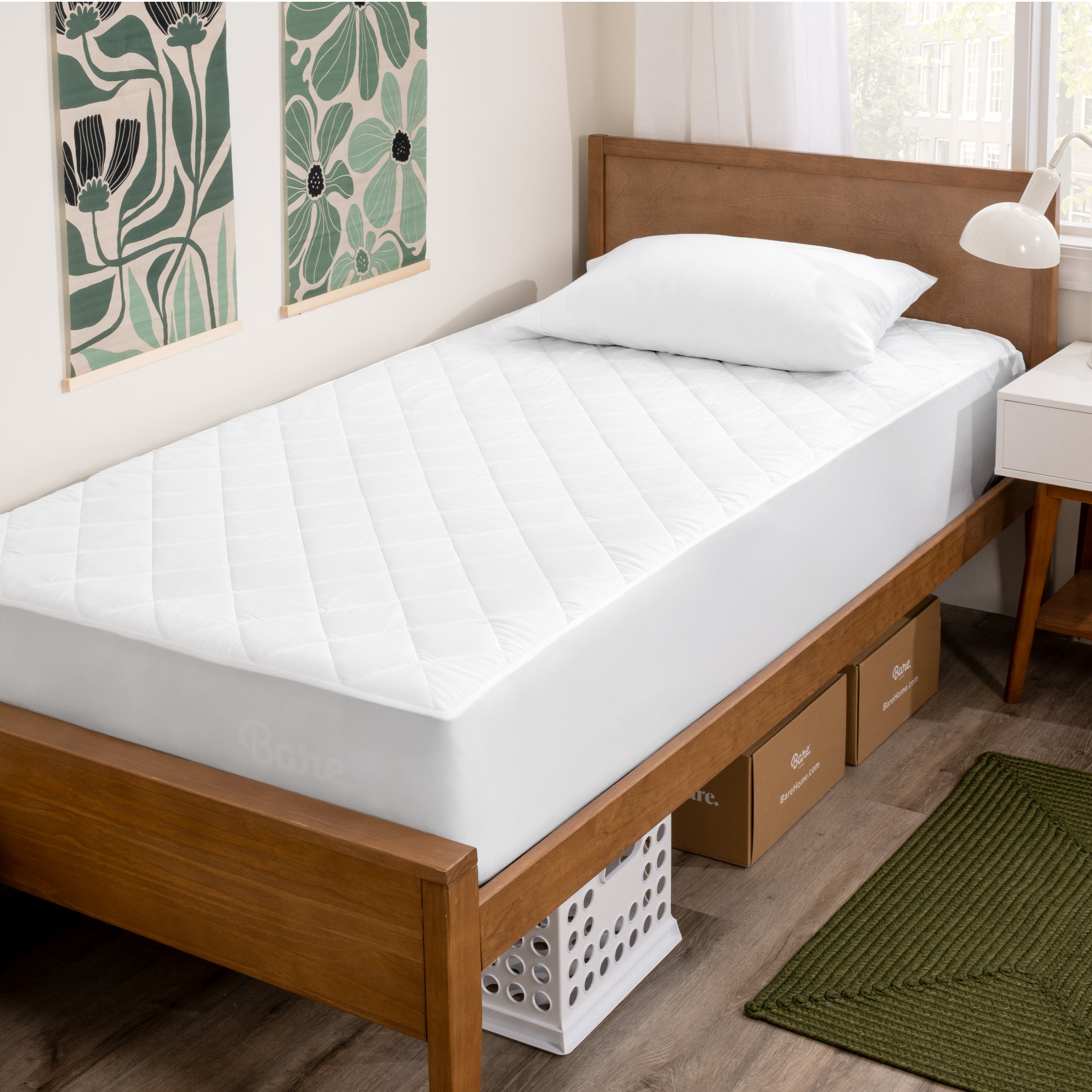 A bed with a wooden bed frame with a quilted mattress pad on.