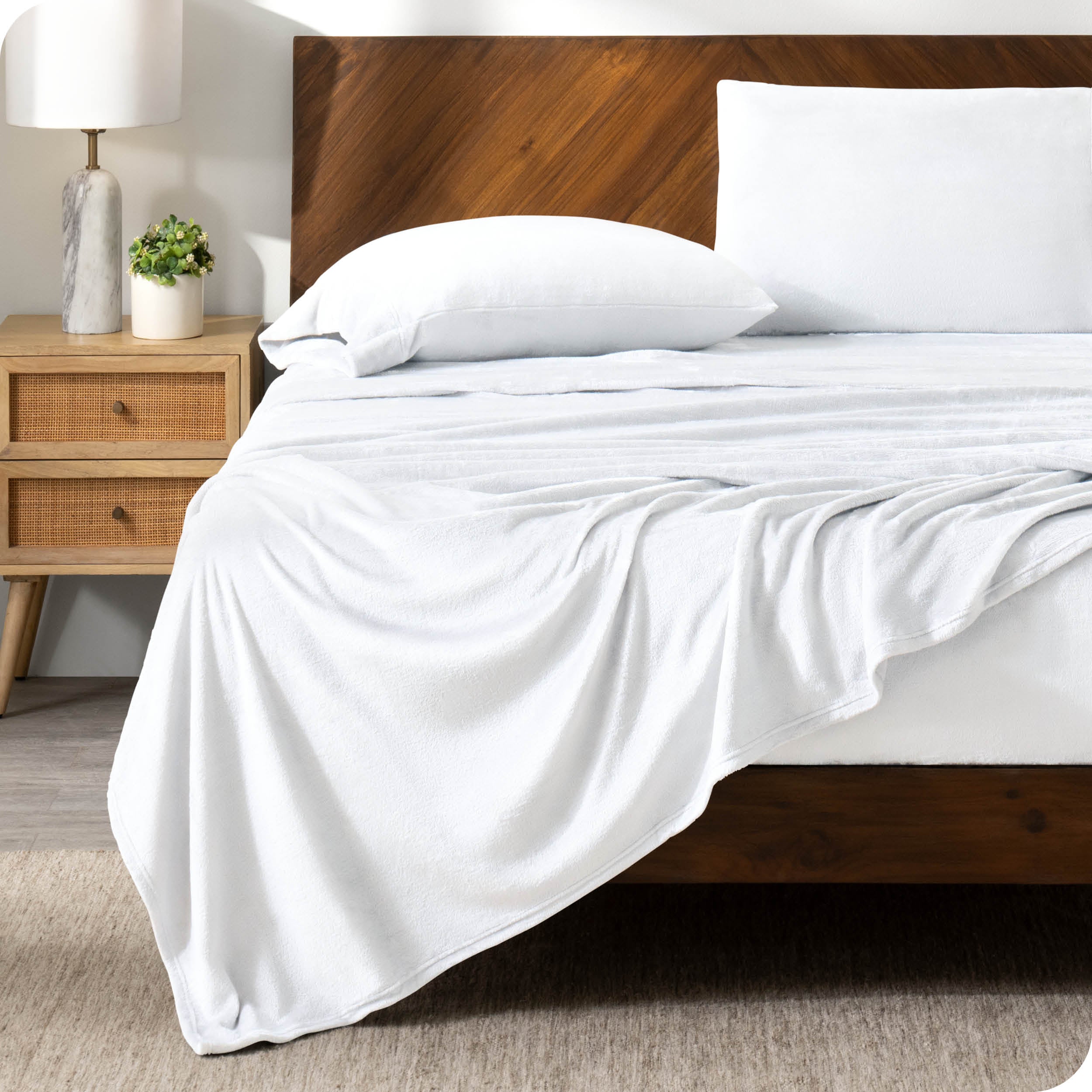 A white sheet set on a bed with a wooden bed frame