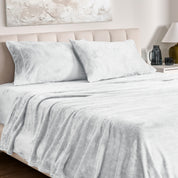 Microplush bed sheets and pillowcases on a bed with a neutral headboard and decor.