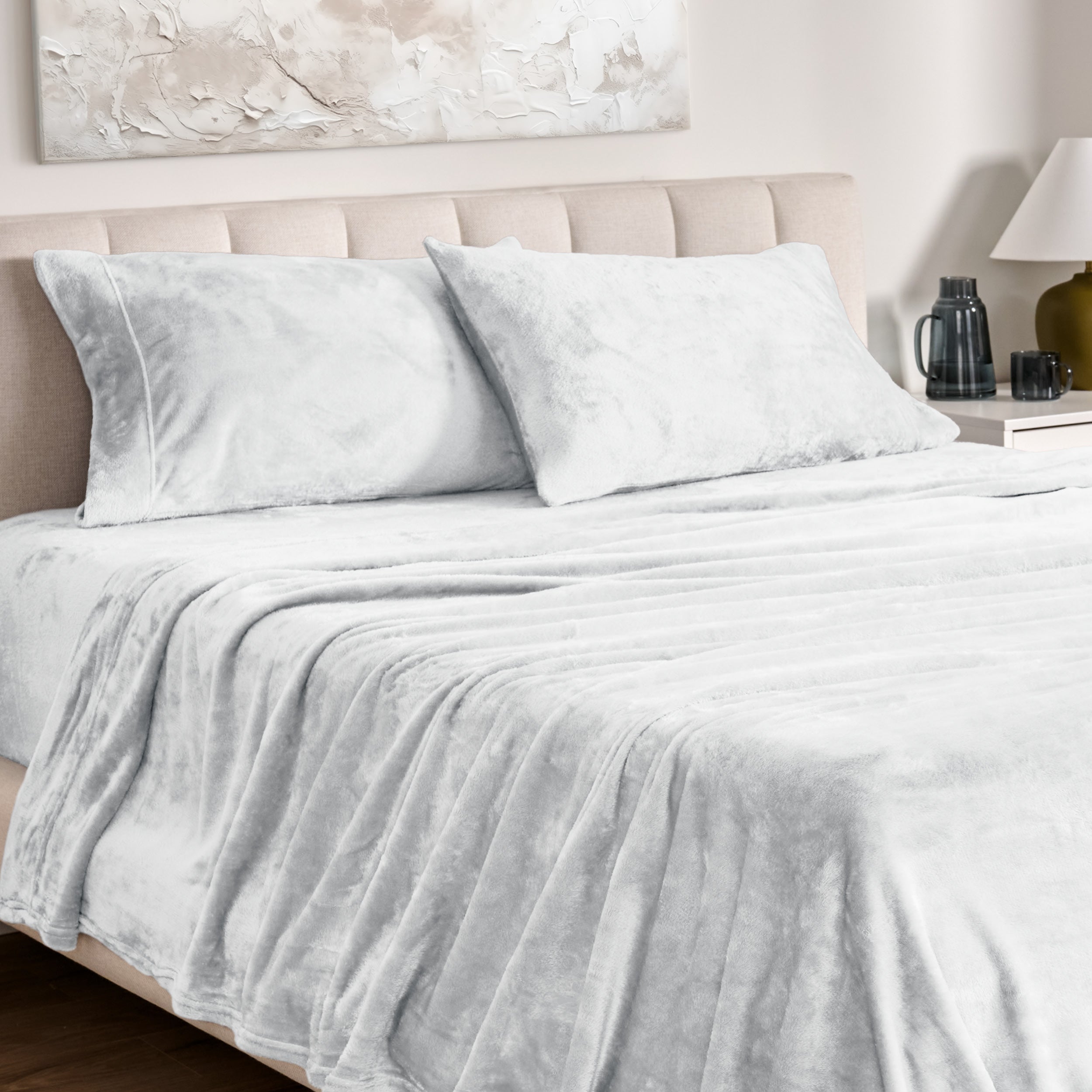 Microplush bed sheets and pillowcases on a bed with a neutral headboard and decor.