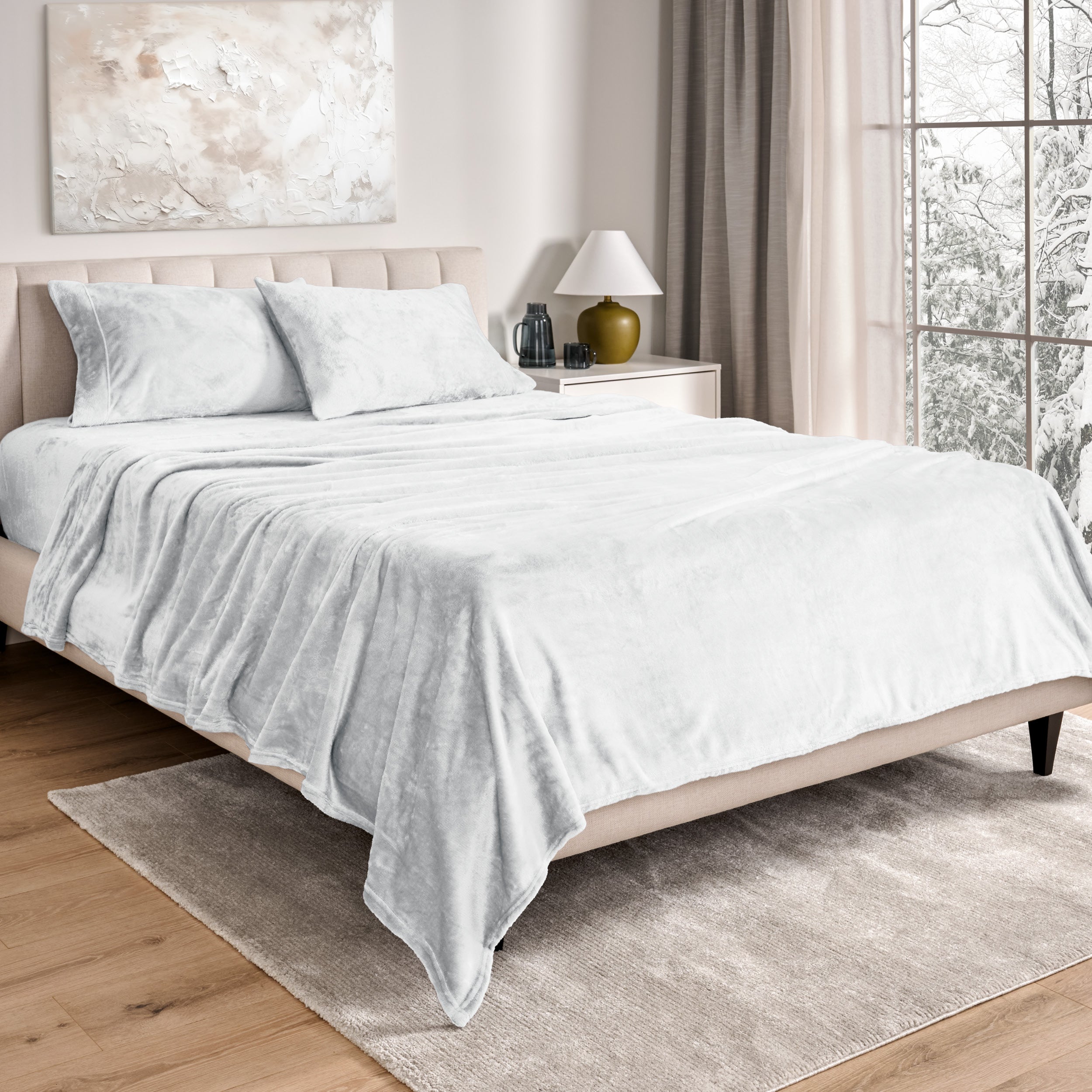 Sheets and matching pillowcases on a bed in a bedroom with a lamp and window in the background.