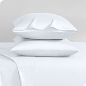 Two sateen pillowcases stacked on a bed