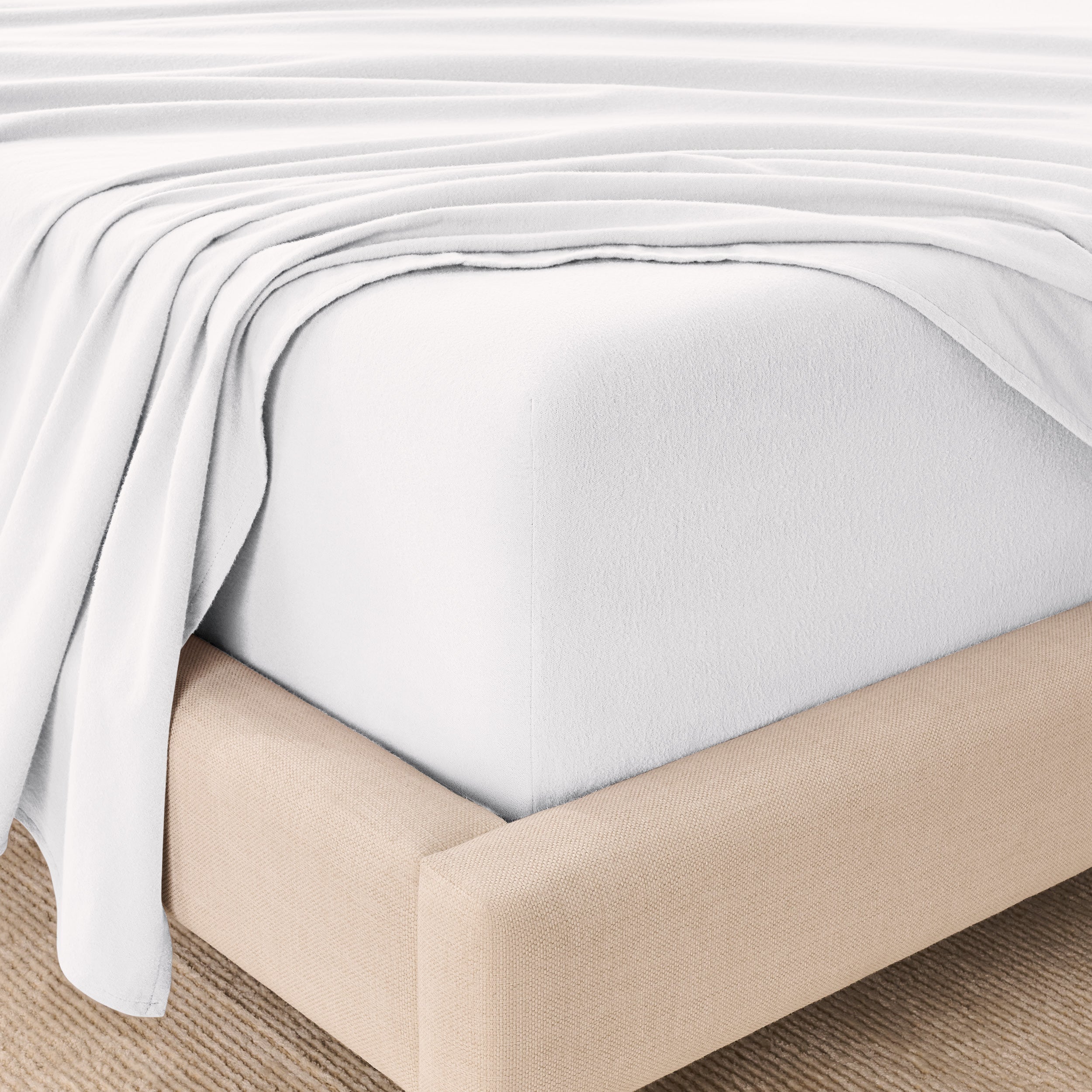 Organic flannel sheets on a beige bed frame