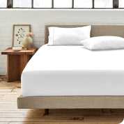 Percale fitted sheet on a mattress with matching pillowcases on pillows