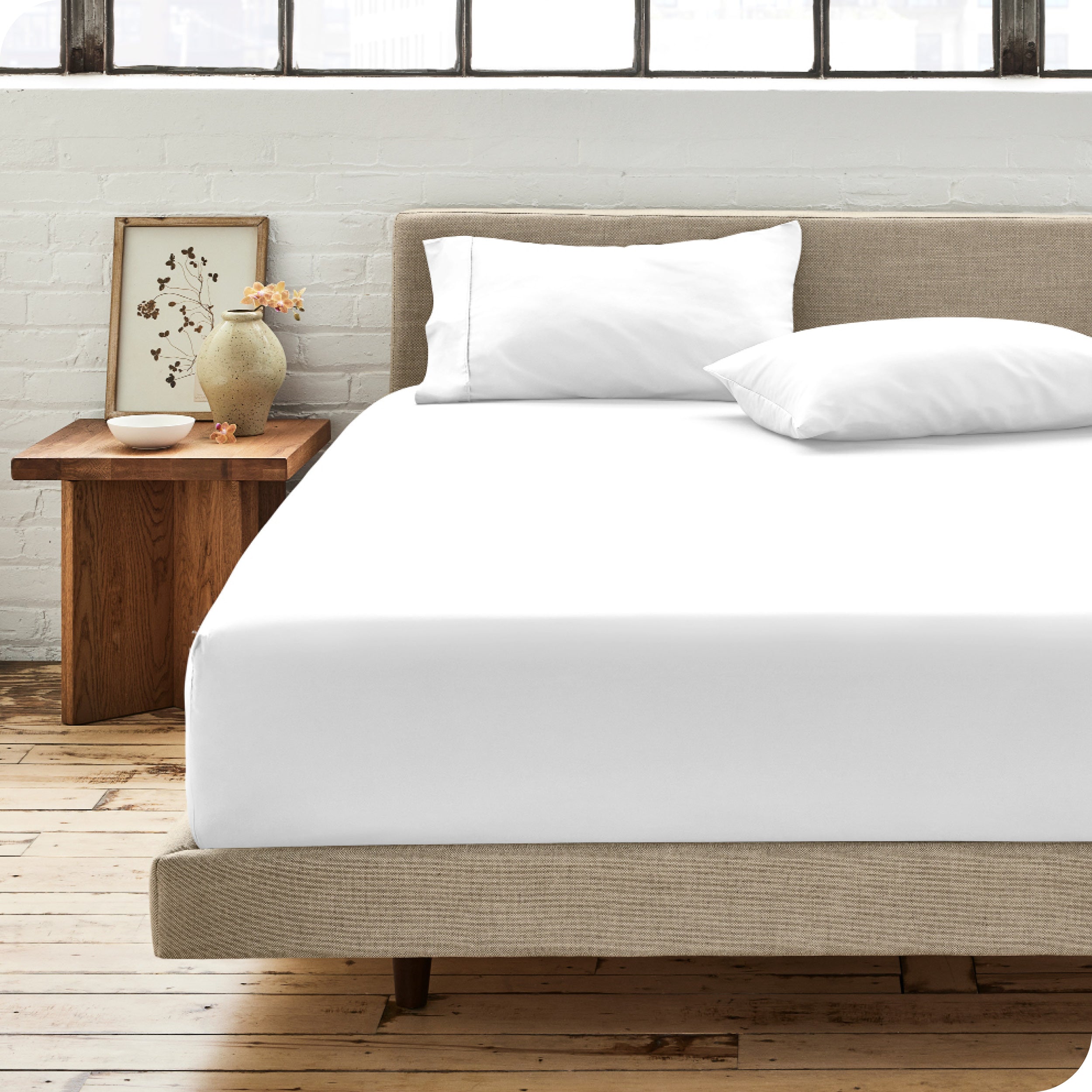 Percale fitted sheet on a mattress with matching pillowcases on pillows