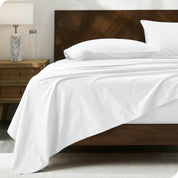Percale sheet set on a bed with a wooden headboard