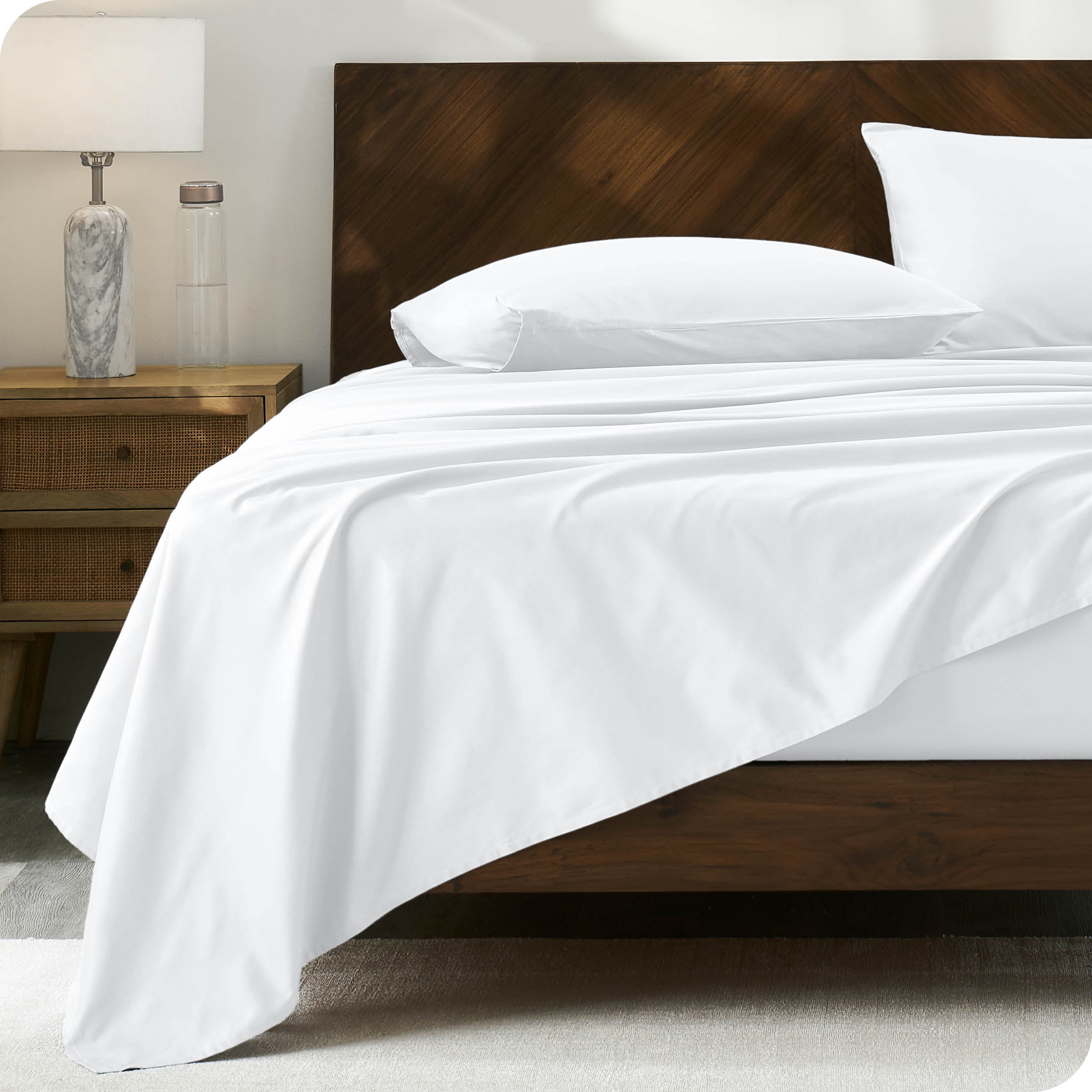 Percale sheet set on a bed with a wooden headboard