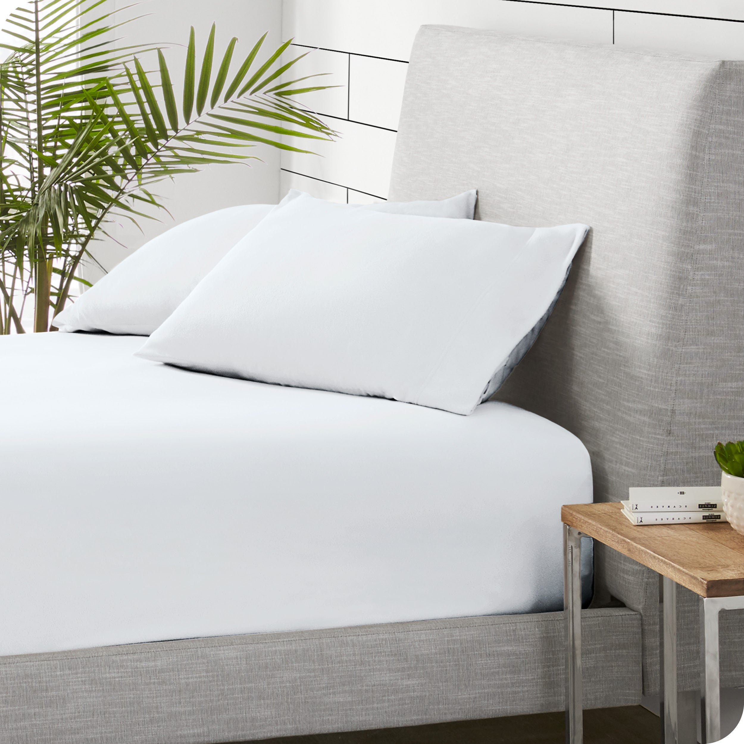 A sideview of a modern bed with a polar fleece fitted sheet on.
