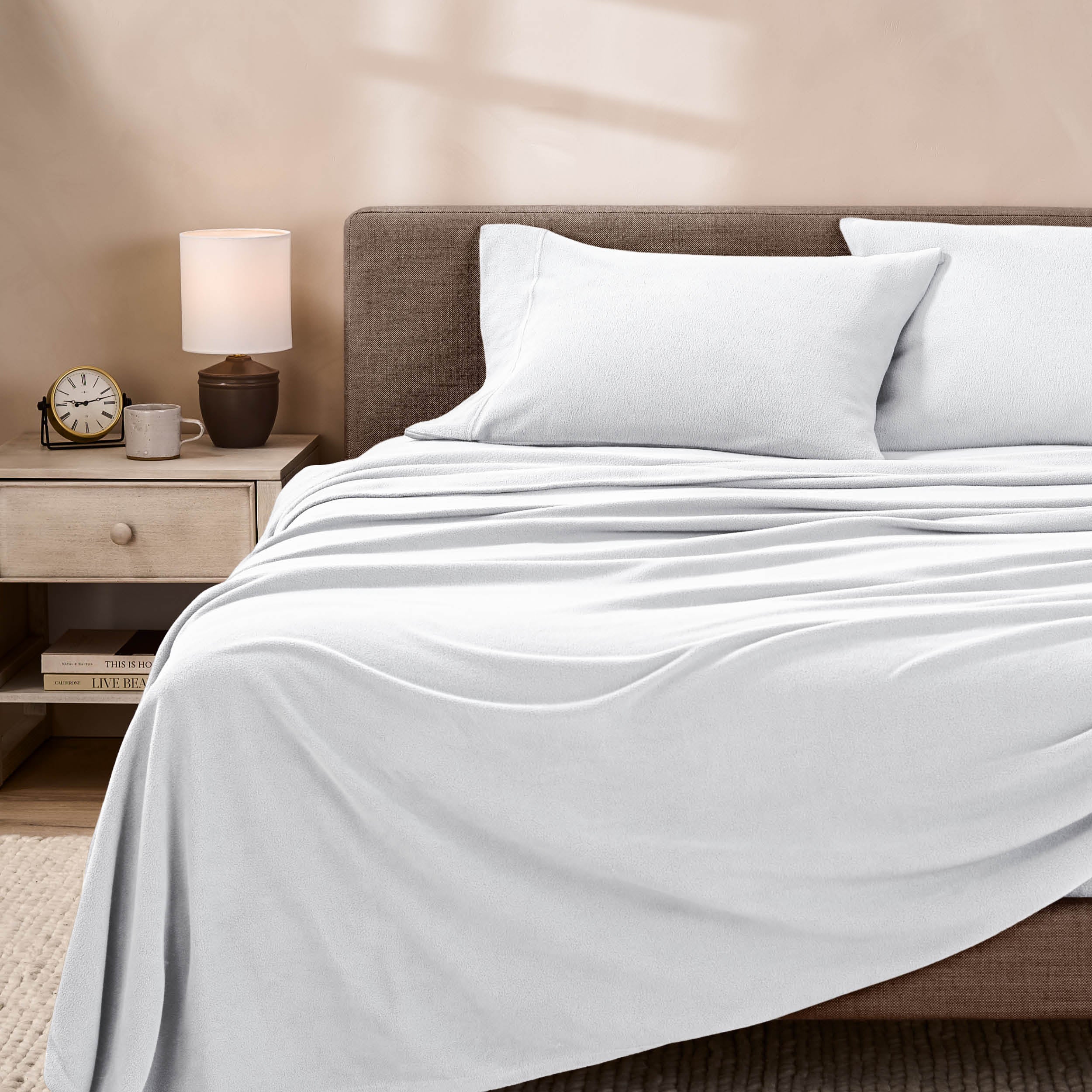 View of fleece sheets from the end of a bed with the top sheet draped over the side and end